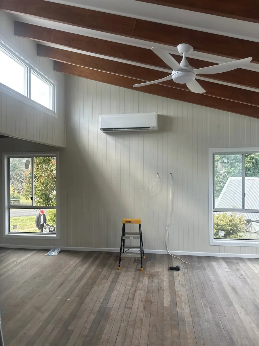 Interior with a wall-mounted air conditioner and ceiling fans